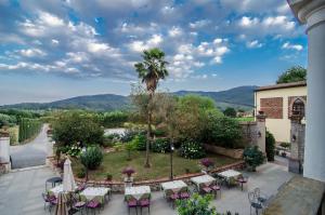 Blick auf einen Garten mit Tischen und Stühlen in der Unterkunft Hotel Villa Cheli in Lucca