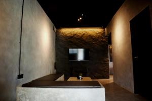 um quarto com uma parede de pedra com um banco em 3DEGREES° em Pantai Cenang