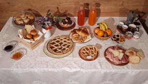 una mesa con muchos tipos diferentes de pan y fruta en B&B EcoAntico casa in paglia en Maiolo