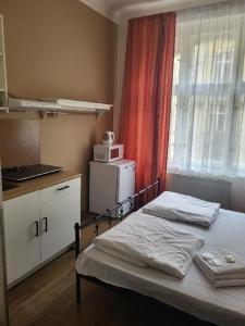 a bedroom with a bed and a kitchen with a window at Sunfower Prague Suites in Prague