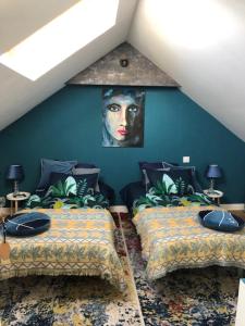 PleurtuitにあるKer Arcadiaのベッドルーム1室(ベッド2台付)が備わります。壁には絵画が飾られています。