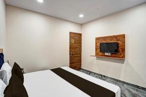 a bedroom with a bed and a tv on the wall at OYO Lord King Hotel in New Delhi
