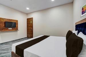 um quarto com uma cama e uma televisão na parede em OYO Lord King Hotel em Nova Deli