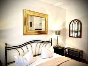 - une chambre avec un lit et un miroir mural dans l'établissement Hotel Mariahilf München, à Munich