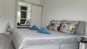 una camera da letto con letto, cuscini blu e specchio di Prázdninový dům u moře a Bilice (Bilizze)