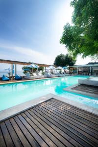 uma grande piscina com água azul e cadeiras em AMP Beach House em Nusa Penida