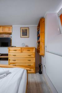 a bedroom with a bed and a wooden dresser at The Secret Spot 1BD Apartment in Sofia
