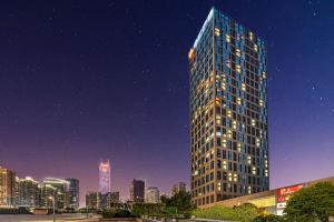 广州Poly Pivot International Aparthotel Guangzhou East Railway Branch - Free Shuttle Bus to Canton Fair Complex During Canton Fair Period的夜晚城市中的高楼