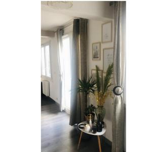 a living room with a table and a window at Appartement Cosy- Emplacement Idéal pour les JO ! in Vanves
