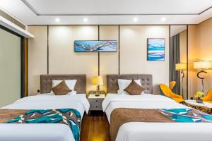 广州Poly Pivot International Aparthotel Guangzhou East Railway Branch - Free Shuttle Bus to Canton Fair Complex During Canton Fair Period的有两张床和一张桌子的酒店房间