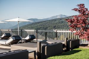 a group of lounge chairs and an umbrella on a patio at Hotel Ambet in Maranza