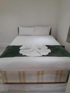Una cama blanca con una manta encima. en The w3 flat en Londres
