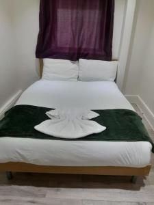 a bed with a green and white blanket on it at The w3 flat in London