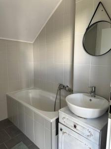 a bathroom with a tub and a sink and a mirror at Mašenka in Gospić