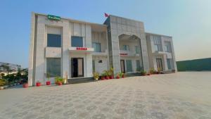 a large building with a courtyard in front of it at The God's Palace Resort in Meerut