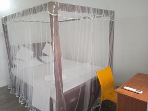 1 dormitorio con escritorio y silla amarilla en Rangani Lagoon Resort, en Kalpitiya