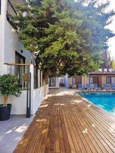 a deck with a tree next to a swimming pool at Hotel Centro Bodrum in Bodrum City