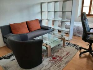 een woonkamer met een bank en een glazen tafel bij Wachau - Angenehm ruhiges Zimmer 5 in Mautern