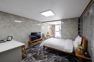 um quarto com uma cama e uma sala de estar em Central Gwangju Hotel & Residence em Gwangju