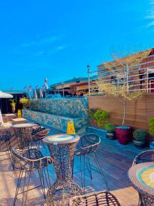 an outdoor patio with tables and chairs and the ocean at Shine Boutique Hotel in Tagum
