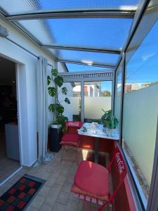 a patio with red chairs and a table on a balcony at Chambre dorée in Pleurtuit