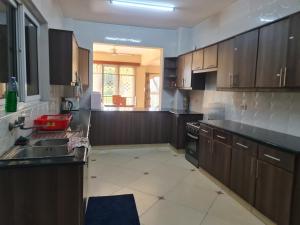 a large kitchen with wooden cabinets and a sink at Flix holdings- Apa apartments mombasa in Mombasa +33 photos