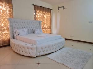 a large white bed sitting in a room at Flix holdings- Apa apartments mombasa in Mombasa