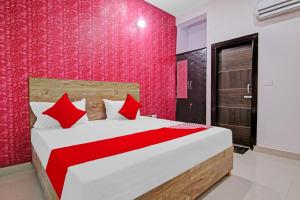 a bedroom with a large bed with red pillows at OYO Flagship Hotel Suncity in Faridabad