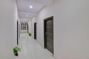 a hallway with black doors and potted plants at OYO Flagship Hotel Suncity in Faridabad