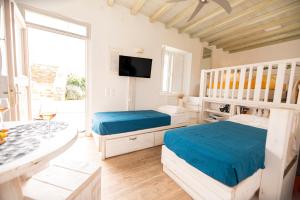 a bedroom with two beds and a television in it at Opus apartment in Agios Stefanos