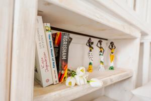 un estante de libros con libros y estatuillas. en Opus apartment en Agios Stefanos