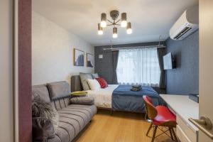 ein kleines Schlafzimmer mit einem Bett und einer Couch in der Unterkunft Felice Nishi-Shinjuku in Tokio