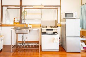 uma pequena cozinha com um lavatório e um frigorífico em かぐら庵 em Kitakata