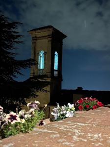 a building with a clock tower in the background with flowers at Monastero del 600 vista Firenze in Calenzano