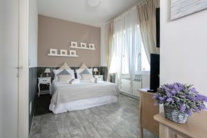 una camera da letto con letto, lenzuola e cuscini bianchi di Residenza il Punto a Perugia