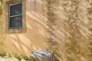 a building with a window and a rock in front of it at Axion Studios in Aroniadika