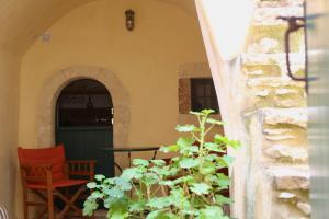 a patio with a red chair and a table and a plant at Axion Studios in Aroniadika