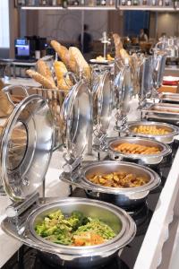 una línea de buffet con muchos platos de comida en Siam Mandarina Hotel - Free BKK Airport Shuttle en Lat Krabang
