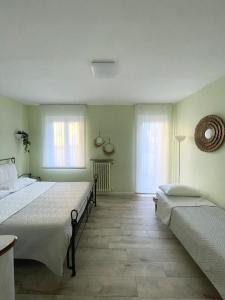 a bedroom with two beds and two windows at Villa Mia Lugano Lake in Brusimpiano