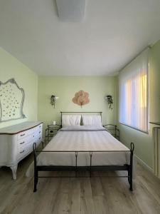 a bedroom with a bed and a dresser and a window at Villa Mia Lugano Lake in Brusimpiano