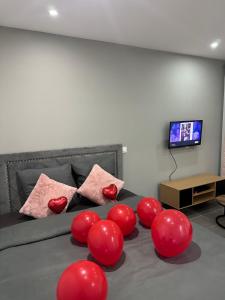 a bedroom with red balloons on a bed with a television at Lov’SPA 2 in Fleury-Mérogis