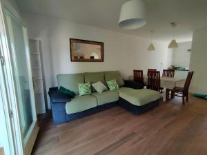 - un salon avec un canapé et une table dans l'établissement Casita con jardin, parking, bicis, padel surf, à Ampurias