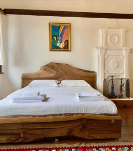 a bedroom with a wooden bed with two towels on it at HOTEL ANSEL in Berat