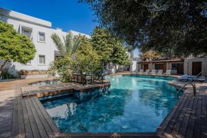 ein Schwimmbad mit Stühlen und ein Gebäude in der Unterkunft Hotel Centro Bodrum in Bodrum City