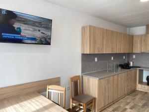 a room with a kitchen with a counter and a tv on the wall at Hostel Flora Mezdra in Mezdra