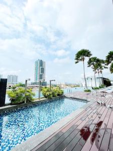 Una piscina con tumbonas junto a un edificio. en Kajang Oasis@MKH Boulevard, en Kajang