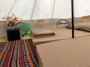 a tent room with two beds and a fan at TODO Farm - Organic Farming & Retreat in Phu Yen