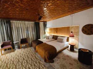 um quarto de hotel com duas camas e uma cadeira em Khanda Kothi em Srinagar