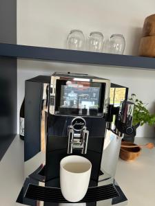een koffiezetapparaat met een kopje op een plank bij Parenthèse d'Opale in Wimille