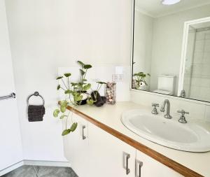 a bathroom with a sink and a mirror at Driftwood Townhouse - Waterfront-Central Location in Lakes Entrance
